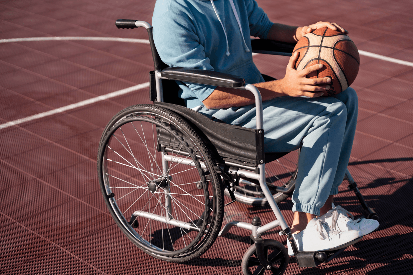 Persona en silla de ruedas sosteniendo un balón de baloncesto