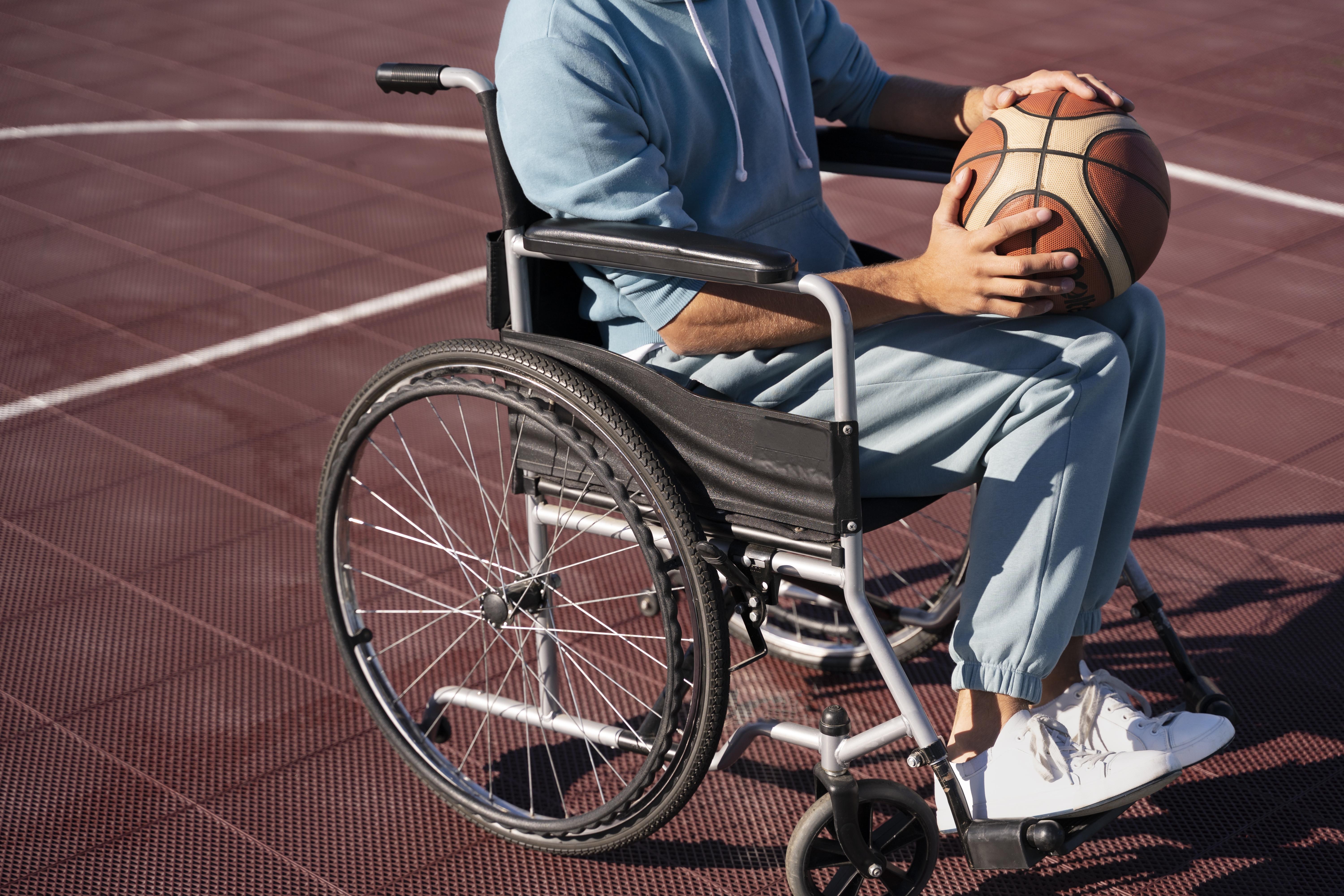 Persona en silla de ruedas sosteniendo un balón de baloncesto
